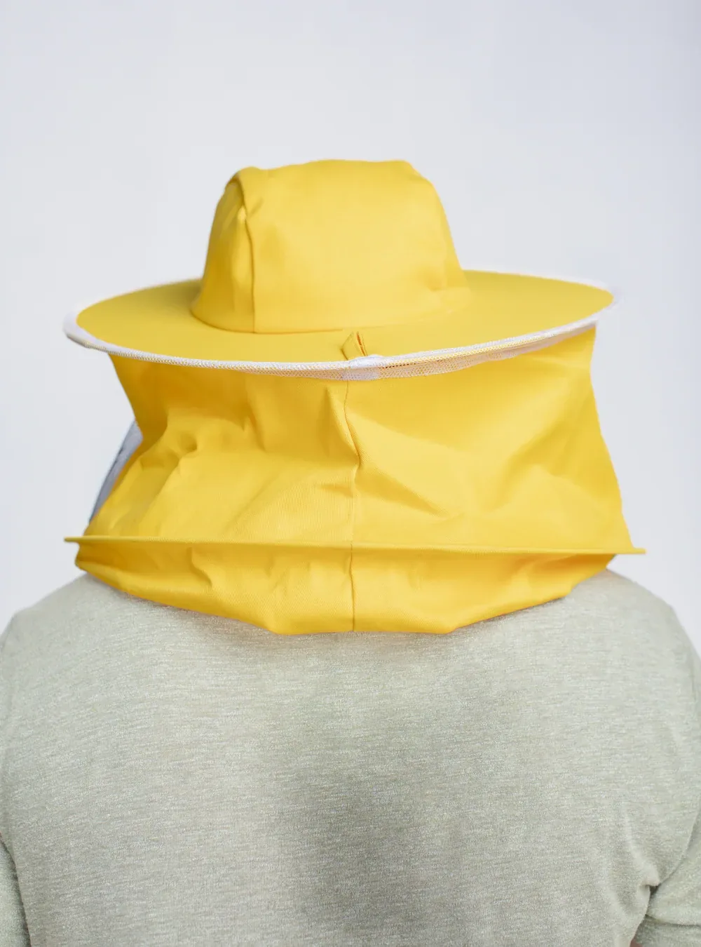 Back view of a round hat veil, with the fabric skirt drawn down over the shoulders