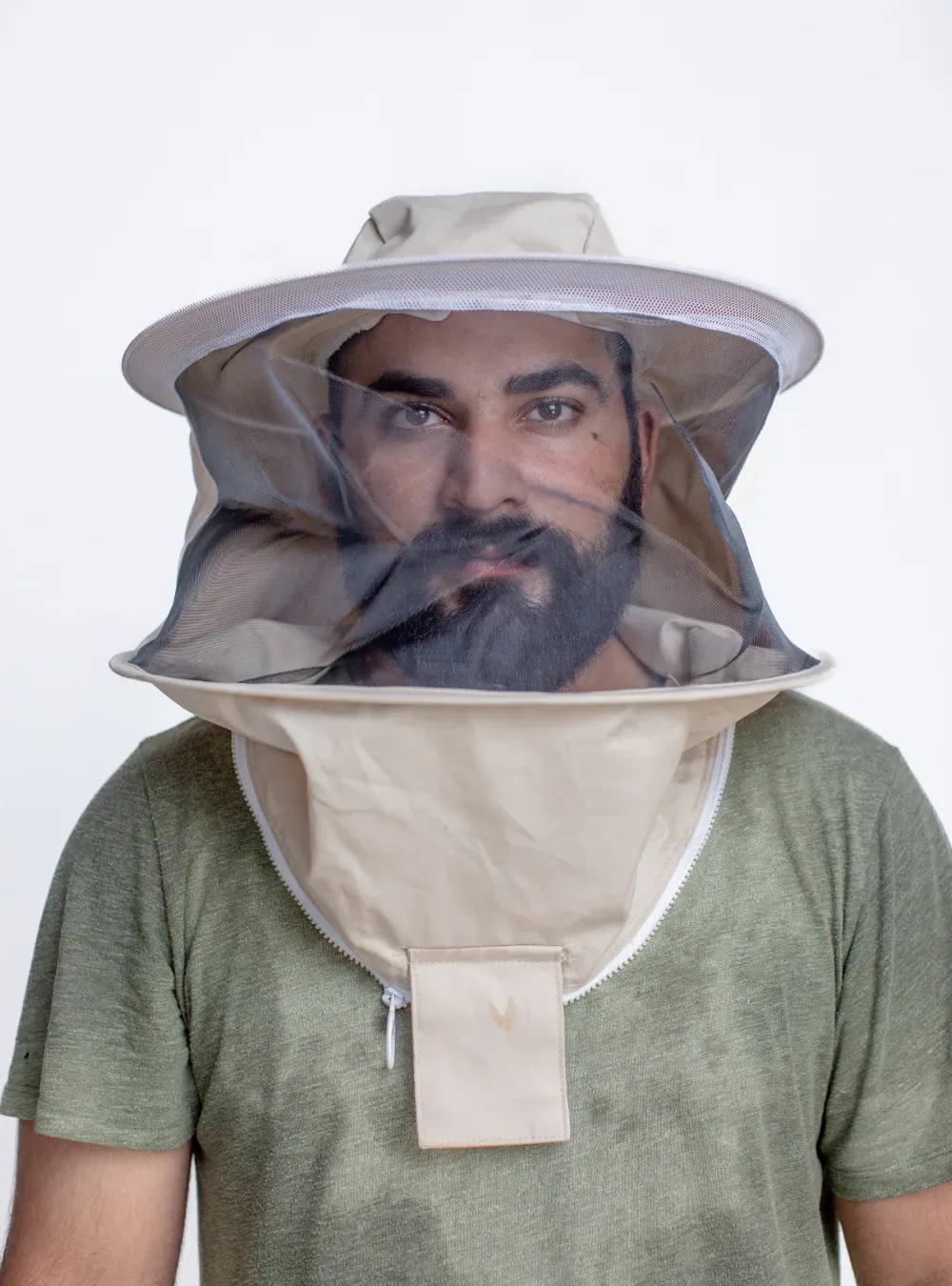 Beekeeper wearing a round veil, with mesh hanging from a wide-brimmed hat